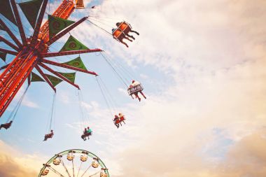 sürme sürmek ve bir eyalet fuarında bir retro vintage instagram filtre uygulama veya eylem ile tonda alacakaranlıkta yaz atmosferinin tadını insanlar