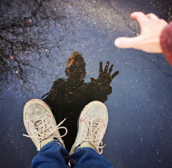 反射を持つ人は レトロなヴィンテージ Instagram フィルター効果アプリまたはアクションにトーンの水の木と雨後水たまり — ストック写真