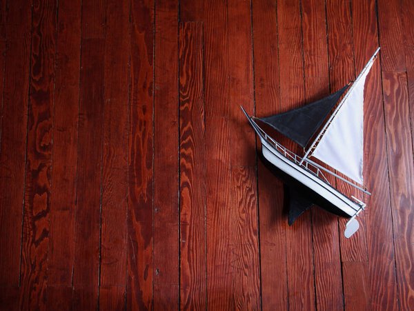 старая модель парусной лодки из дерева на паркете с драматическим освещением тонизируется с винтажным ретро-Instagram фильтр эффект приложения или действия
