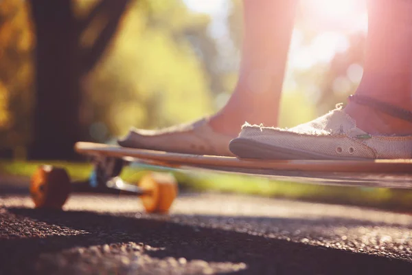 日の出や日没のレトロなビンテージ Instagram フィルター アプリケーションまたはアクション効果トーン中にバック グラウンドで草と木が道に乗ってスケートボーダーの広角ショット — ストック写真