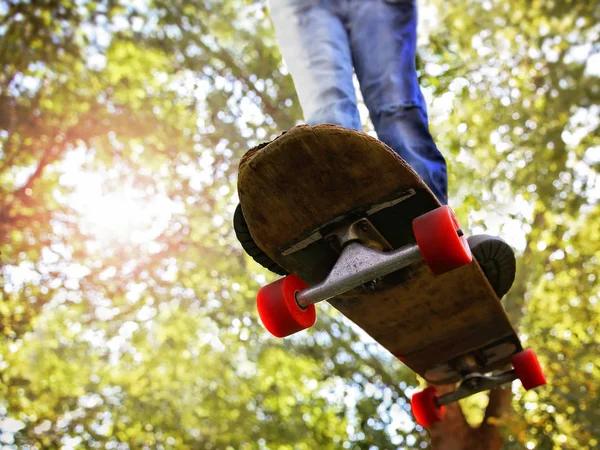 Groothoek Schot Van Een Skateboarder Springen Van Bomen Achtergrond Afgezwakt — Stockfoto