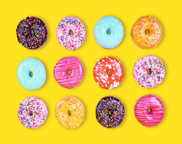 Variedade variada de donuts em um estúdio de fundo amarelo tiro sobrecarga — Fotografia de Stock