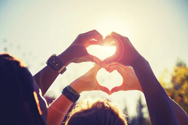 Beautiful photo of a couple making heart shapes with their hands toned with a retro vintage instagram filter — Stock Photo, Image