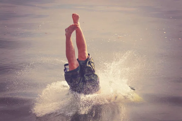 Foto franca de una persona sumergiéndose en el agua tonificada con un filtro de instagram retro vintage — Foto de Stock