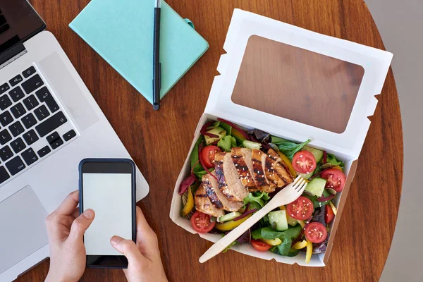 Persoon met behulp van digitale gadgets en eten — Stockfoto