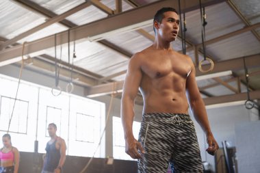 Kaslı adam spor salonunda ayakta