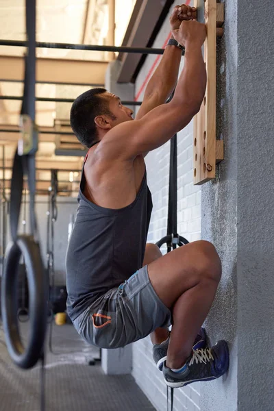 Homem fazendo exercícios de treinamento em pegboard — Fotografia de Stock