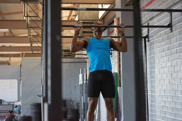 Esportivo homem fazendo pull ups — Fotografia de Stock