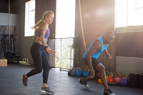 Sportive couple sprinting in gym — Stock Photo, Image