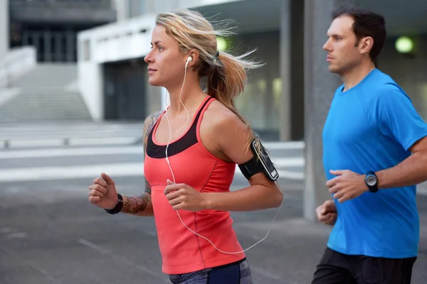 Woman and man jogging in street — Stock Photo, Image
