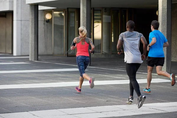 Mensen joggen samen in de buurt van gebouwen — Stockfoto