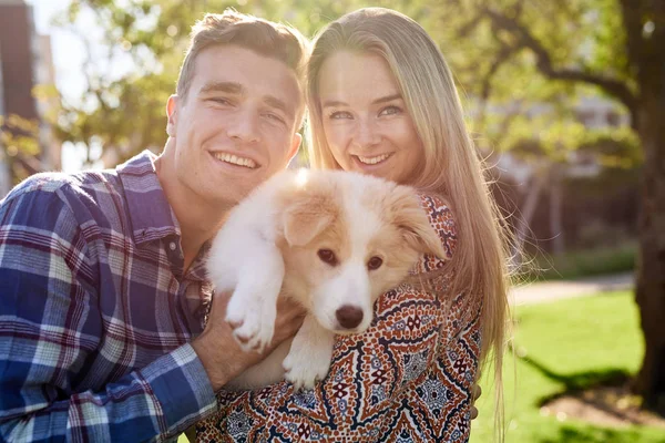 Par leende med bedårande valp — Stockfoto