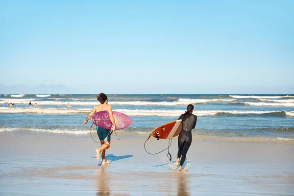 Couple carrying surfboards — Stock Photo, Image