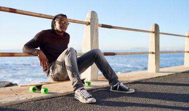 Afrika adam longboard ile oturuyor