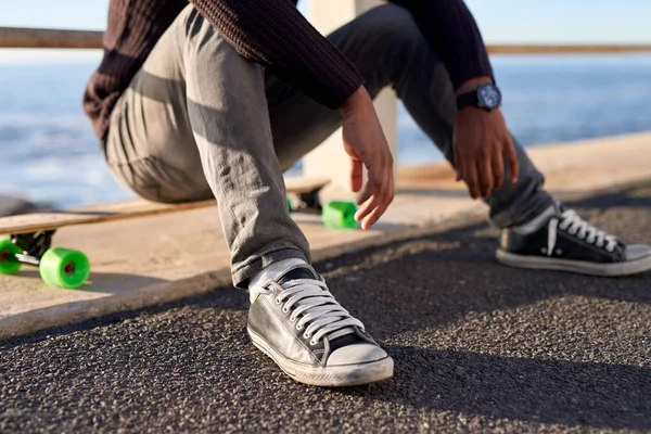 Man sitting on longboard — Stock Photo, Image