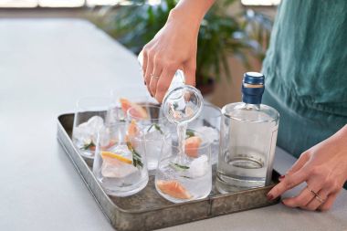 Soda tonik gözlük içine dökme kadın alkollü içecekler parti için hazırlanıyor