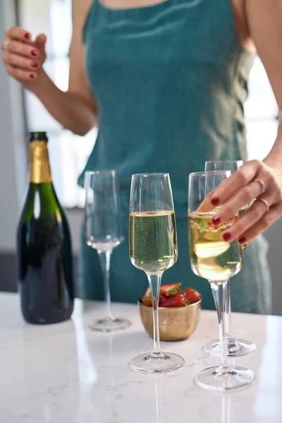 拿着瓶子和草莓杯的香槟杯与气泡在餐桌上 — 图库照片