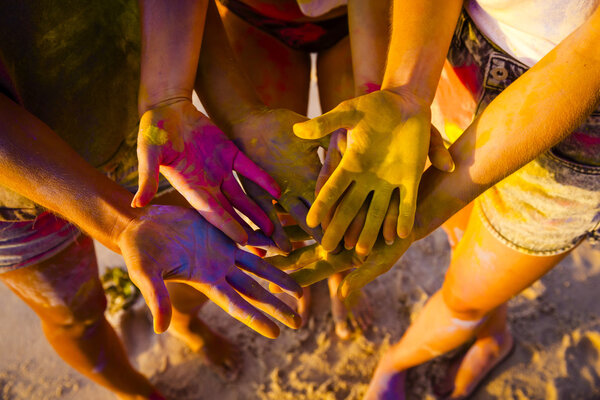female hands full of colored powder 