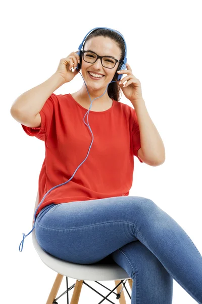 Mujer con auriculares sonriendo y escuchando música —  Fotos de Stock