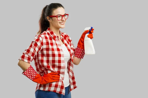Donna sorridente che tiene spray detergente — Foto Stock