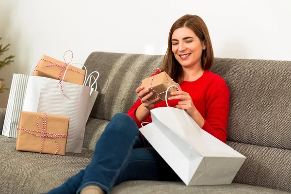 Mujer sentada y preparando regalos para Navidad — Foto de Stock