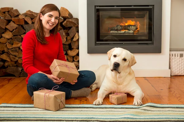 Donna seduta sul pavimento con cane e regali — Foto Stock