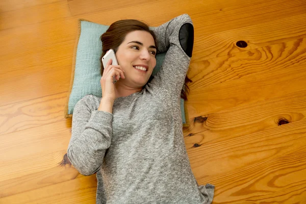 Mujer mintiendo y hablando por teléfono — Foto de Stock