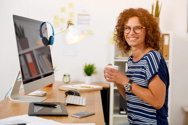 Бізнес-леді сидить і п'є каву в офісі — стокове фото