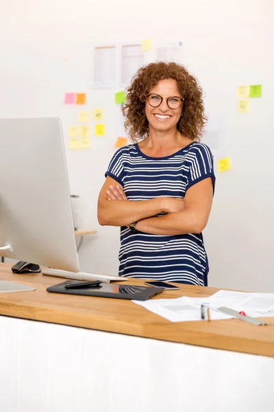 Smiling businesswoman sitting at office — Stock Photo, Image