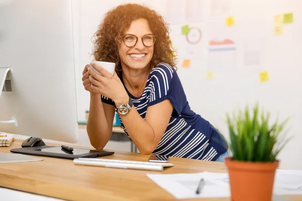 Бізнес-леді сидить і п'є каву в офісі — стокове фото