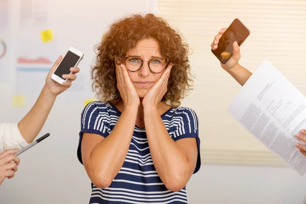 Businesswoman with hands holding smartphones at office — Stock Photo, Image