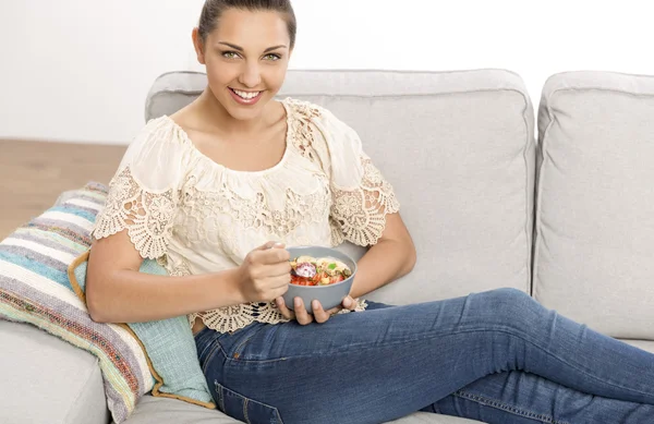 Kobieta w bluzka beżowa, siedząc na kanapie — Zdjęcie stockowe