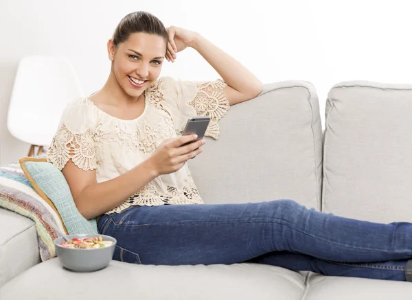 Femme en chemisier beige assise sur canapé — Photo