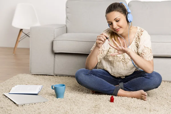 Woman in beige blouse sitting on carpet — Stock Photo, Image