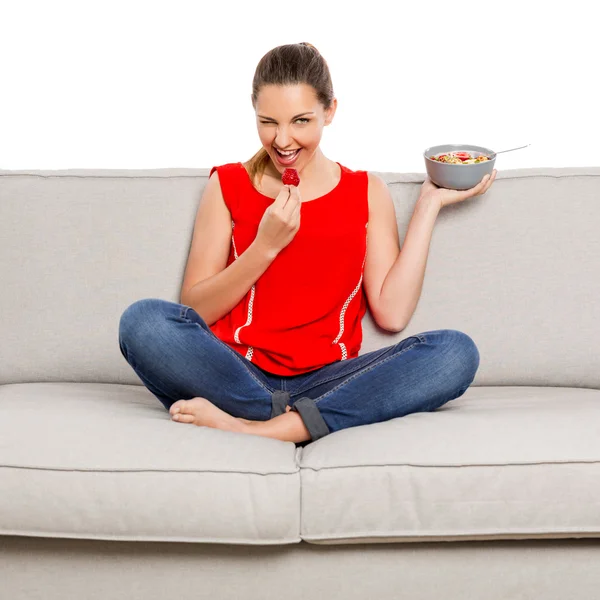 Женщина в красном сингле, сидящая на диване — стоковое фото