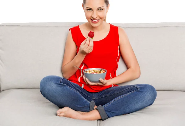 Woman in red singlet sitting on sofa — Stock Photo, Image