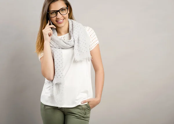 Ładna kobieta stwarzających w okularach i szalik — Zdjęcie stockowe