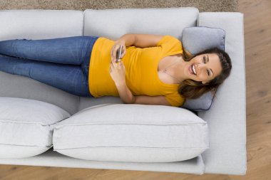 Sarı tişört kanepede yatan kadın