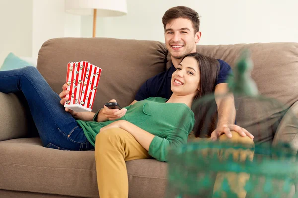 Pareja en sofá comer palomitas de maíz —  Fotos de Stock