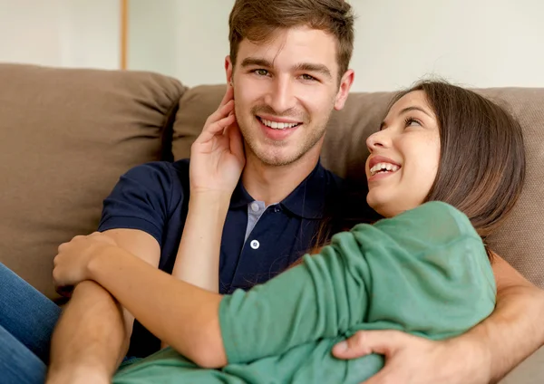 Пара сидит и обнимается на диване — стоковое фото