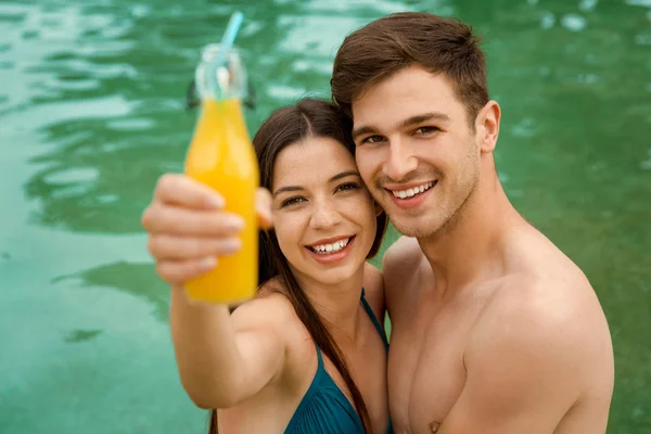 Couple embrassant à l'intérieur de la piscine avec du jus — Photo