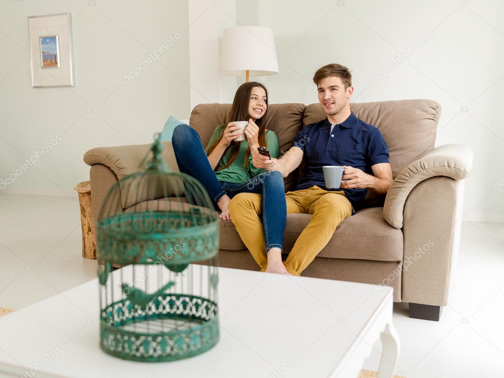 couple drinking coffee while watching tv