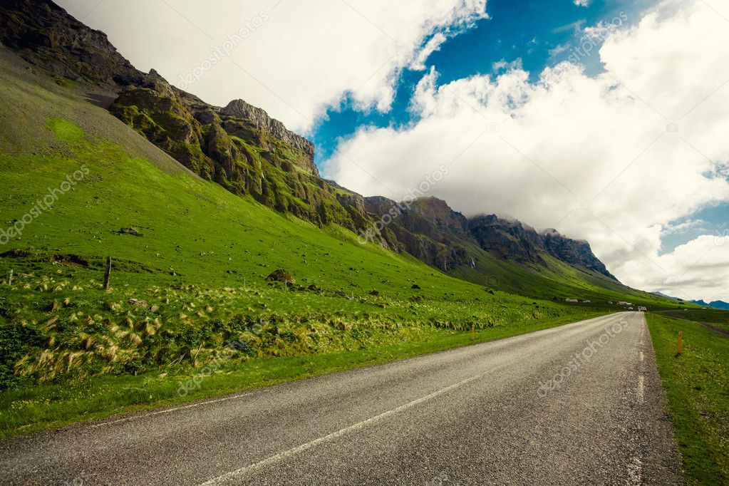 Endless asphalt road near green hills