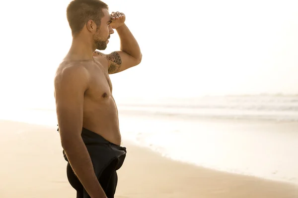 Στέκεται στην παραλία να ψάχνει με τα κύματα surfer — Φωτογραφία Αρχείου