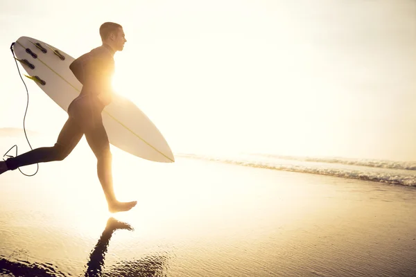 Surfista con tabla de surf corriendo a olas —  Fotos de Stock