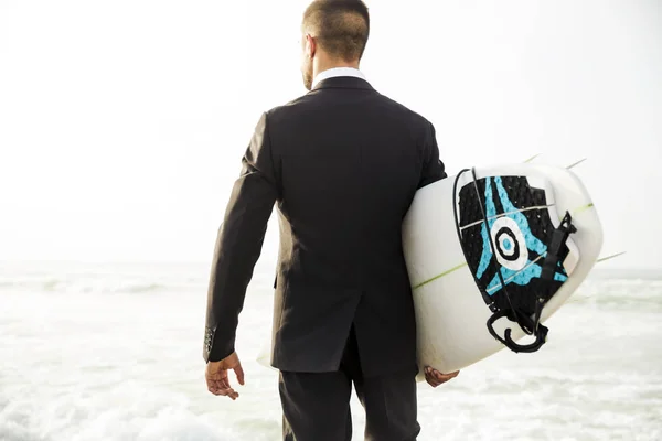 Empresário segurando prancha de surf — Fotografia de Stock