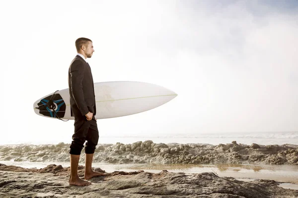 Бизнесмен держит доску для серфинга — стоковое фото