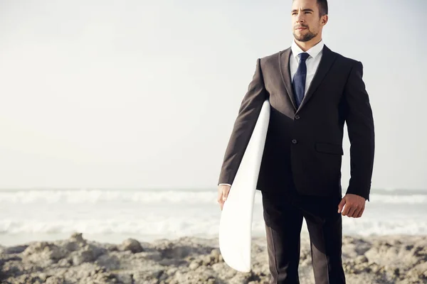 Empresário segurando prancha de surf — Fotografia de Stock
