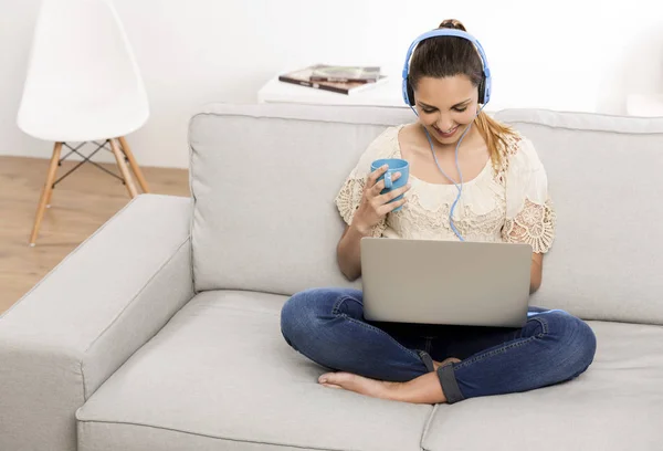 Kvinne hjemme som jobber med laptop – stockfoto