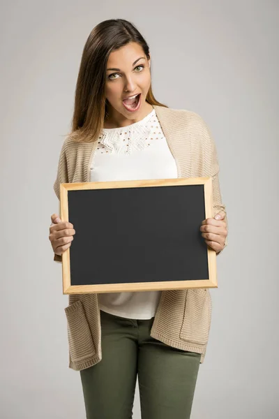 Kvinna innehav tom chalkboard — Stockfoto